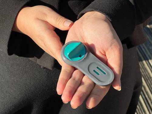 A small neutropenic sepsis blood-testing device held in a woman's hand